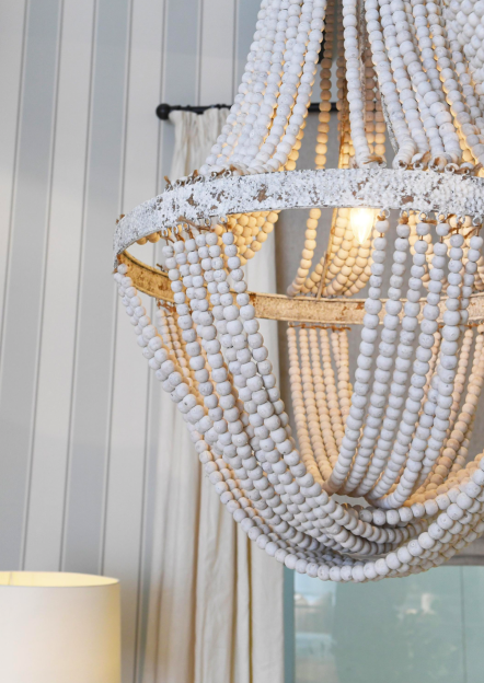 Biały żyrandol z drewnianych koralików w minimalistycznym wnętrzu