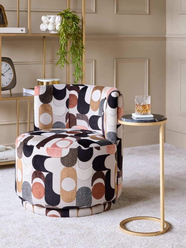 Kolorowy fotel obrotowy do salonu tapicerowany velvet w geometryczne wzory